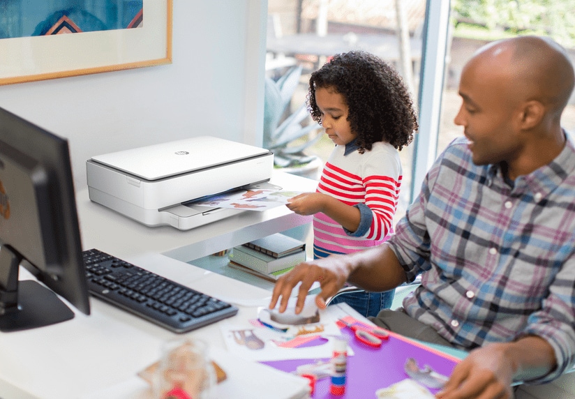 Father and daughter with HP computer and printer